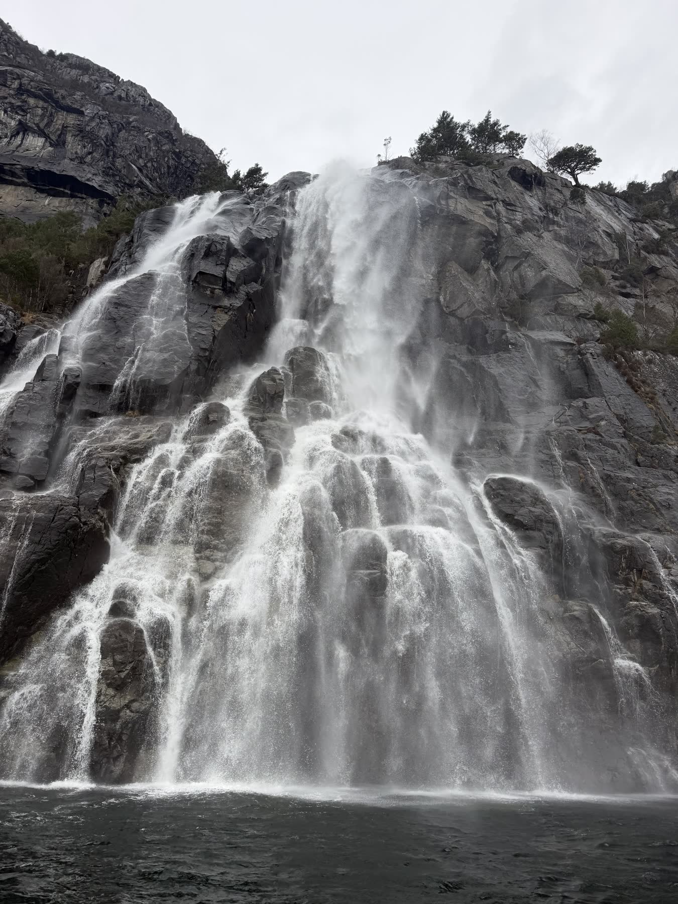 Wasserfall stürzt über eine Felswand in einen Bergsee
